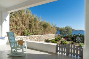 a blue chair sitting on a porch with a view of the water at Villa Agios Isidoros in Gourna