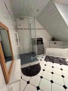 a bathroom with a shower and a black and white tile floor at Kaisers Ferienhaus in Kaifenheim