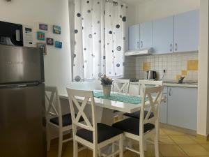 a kitchen with a table with chairs and a refrigerator at Apartments Ivandić in Tučepi