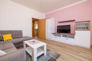 ein Wohnzimmer mit Sofa und Fernseher in der Unterkunft Apartments Darko by the sea in Supetarska Draga