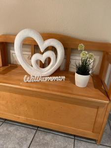 a wooden bench with a heart sculpture on it at Kaisers Ferienhaus in Kaifenheim