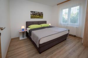 a bedroom with a bed with two green pillows at Apartments Šerbečić in Malinska +97 photos