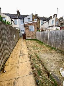 an empty backyard with a fence and houses at Home in Medway in Gillingham