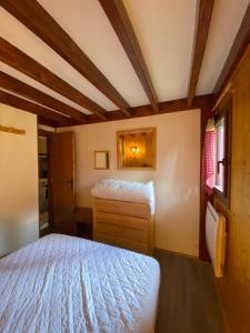 a small bedroom with a bed and a dresser at Chalet mitoyen pres des pistes in Bolquere Pyrenees 2000
