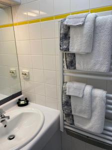 La salle de bains est pourvue de serviettes blanches et d'un lavabo. dans l'établissement Brise de mer sur la naturelle, Studio à Wimereux , parking, à Wimereux 37 autres photos