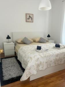 biała sypialnia z łóżkiem i 2 szafkami nocnymi w obiekcie Apartments Ivandić w Tučepi