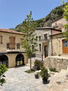 Una gran casa de piedra con un patio en el frente. en Sea Apartments Dhërmi, en Dhërmi