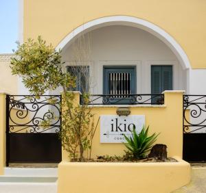 un edificio giallo con un cartello sul lato di Italo di Ikio Concept Santorini a Pyrgos