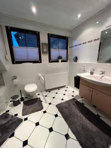 a white bathroom with a sink and a toilet at Kaisers Ferienhaus in Kaifenheim