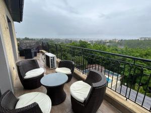 einen Balkon mit Stühlen, einem Tisch und Aussicht in der Unterkunft Magnifique Villa avec piscine Beaujolais in Gleizé