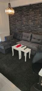 sala de estar con sofá y mesa de centro en Bella apartman, en Mladenovac
