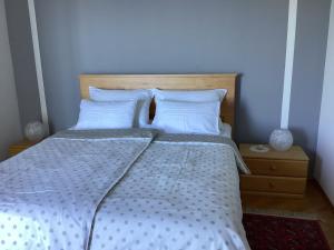 ノヴィ・ヴィノドロスキーにあるDie Appartements Glavas,Eckwohnunge für 2 Personenの白いシーツと枕が備わったベッドのある寝室