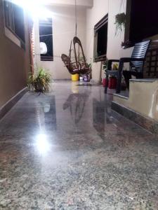a living room with a concrete floor and chairs at Sahana Villa in New Hampi +11 photos