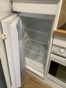 un réfrigérateur vide avec sa porte ouverte dans une cuisine dans l'établissement Brise de mer sur la naturelle, Studio à Wimereux , parking, à Wimereux