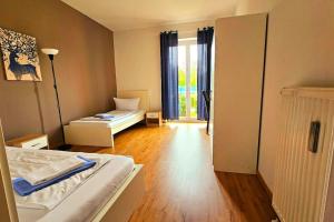 a bedroom with a bed and a room with a window at Apartment number 3 in Oberschleißheim