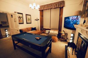sala de estar con mesa de billar y TV en Doune Guest House, en St Andrews