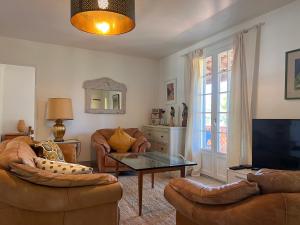 ein Wohnzimmer mit zwei Sofas und einem Fernseher in der Unterkunft Villa Alexandra in La Croix-Valmer