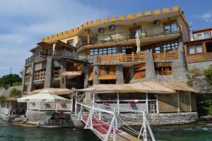 a building on the water in front of a river at Castle waterfront apartments in Dinoša