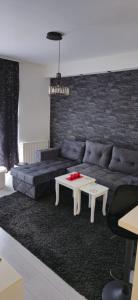 sala de estar con sofá azul y mesa en Bella apartman, en Mladenovac