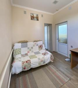 una camera con un letto con una trapunta sopra di Tian-Shan Guest House a Balykchy