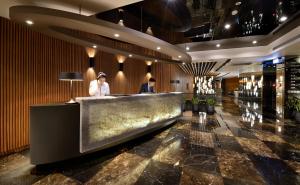 two people standing at a bar in a hotel lobby at Park City Hotel - Hualien Vacation in Hualien City