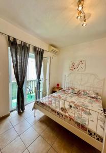 ein Schlafzimmer mit einem Bett und einem großen Fenster in der Unterkunft Villa Nela in Tivat