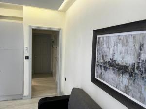 a living room with a couch and a painting on the wall at ADIRAMAR Apartments in Obzor