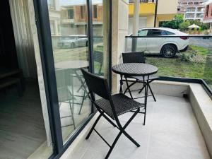 a table and chairs on a balcony with a view of a car at ADIRAMAR Apartments in Obzor