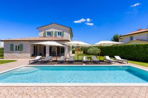 - une piscine en face d'une maison avec des parasols dans l'établissement Villa Dionis, à Kaštelir
