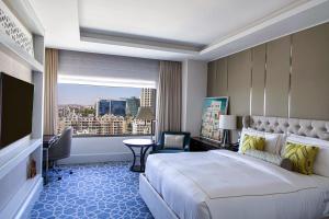 a hotel room with a large bed and a window at Fairmont Amman in Amman