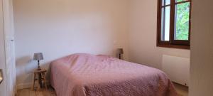 a bedroom with a bed with a pink blanket and a window at Maison au calme, proche Chambéry in Vimines