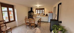 a kitchen with a table and chairs and a refrigerator at Maison au calme, proche Chambéry in Vimines +2 photos