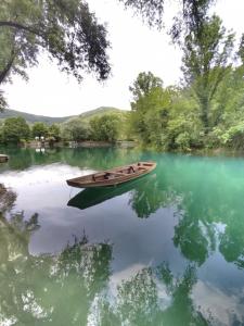 un barco sentado en el agua en un lago en Kuca Delić, en Račić