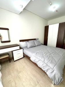 - une chambre avec un grand lit et un bureau dans l'établissement Apartemen Podomoro City Deli Park Medan, à Medan