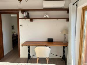 ein Schreibtisch in einem Zimmer mit einem weißen Stuhl in der Unterkunft Villa Caprice in Lloret de Mar