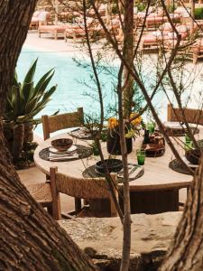 a table with plates of food on it next to a pool at The Wild by Interni in Kalafatis