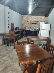 Pousada Casa da Maga - Vila Germânica في بلوميناو: مطبخ مع طاولات وكراسي خشبية في الغرفة