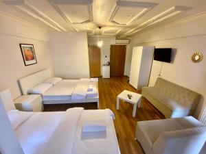 une chambre d'hôtel avec deux lits et un canapé dans l'établissement Akaretler Vera Suites, à Istanbul