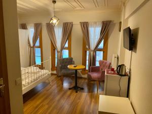 - un salon avec une table, des chaises et des fenêtres dans l'établissement Akaretler Vera Suites, à Istanbul
