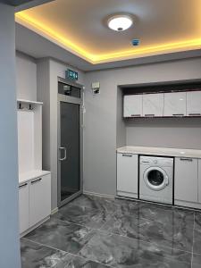 eine Waschküche mit einer Waschmaschine und einer Tür in der Unterkunft YALI Apart Hotel in Trabzon