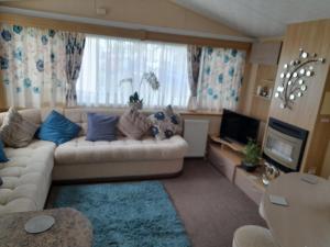 a living room with a couch and a television at Blancos by the sea in Saint Osyth
