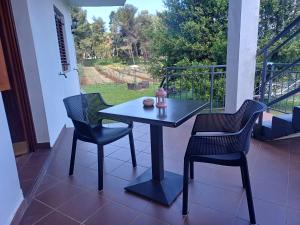 a black table and chairs on a porch with a view at Apartments & Rooms Darrer in Poreč
