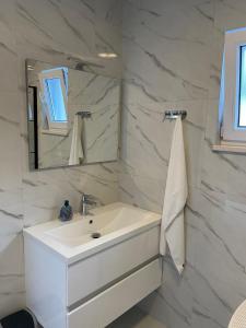 a white bathroom with a sink and a mirror at Villa Anna's heaven in Imotski