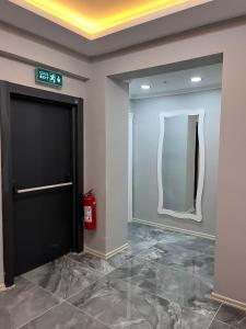 eine Lobby mit einer schwarzen Tür und einem Spiegel in der Unterkunft YALI Apart Hotel in Trabzon