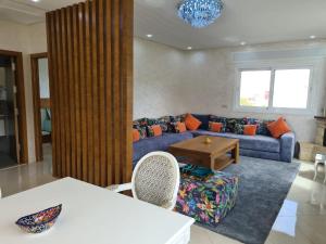 a living room with a blue couch and a table at Appartements Horizon in M'diq