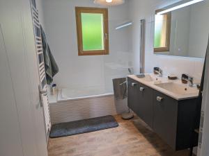 une salle de bain avec une baignoire et un lavabo et une baignoire dans l'établissement Jolie maison landaise tout confort, à Lugos 21 autres photos