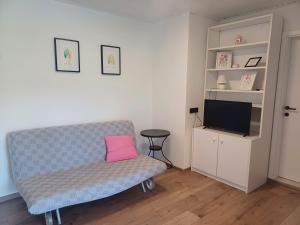 a living room with a couch with a pink pillow at Apartments & Rooms Darrer in Poreč