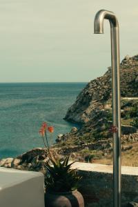 a view of the ocean with a street light and flowers at The Wild by Interni in Kalafatis
