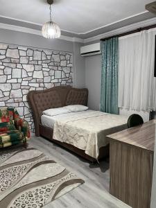 ein Schlafzimmer mit einem Bett und einer Steinmauer in der Unterkunft YALI Apart Hotel in Trabzon