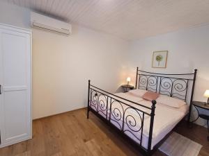 a bedroom with a black bed in a room at Apartments & Rooms Darrer in Poreč